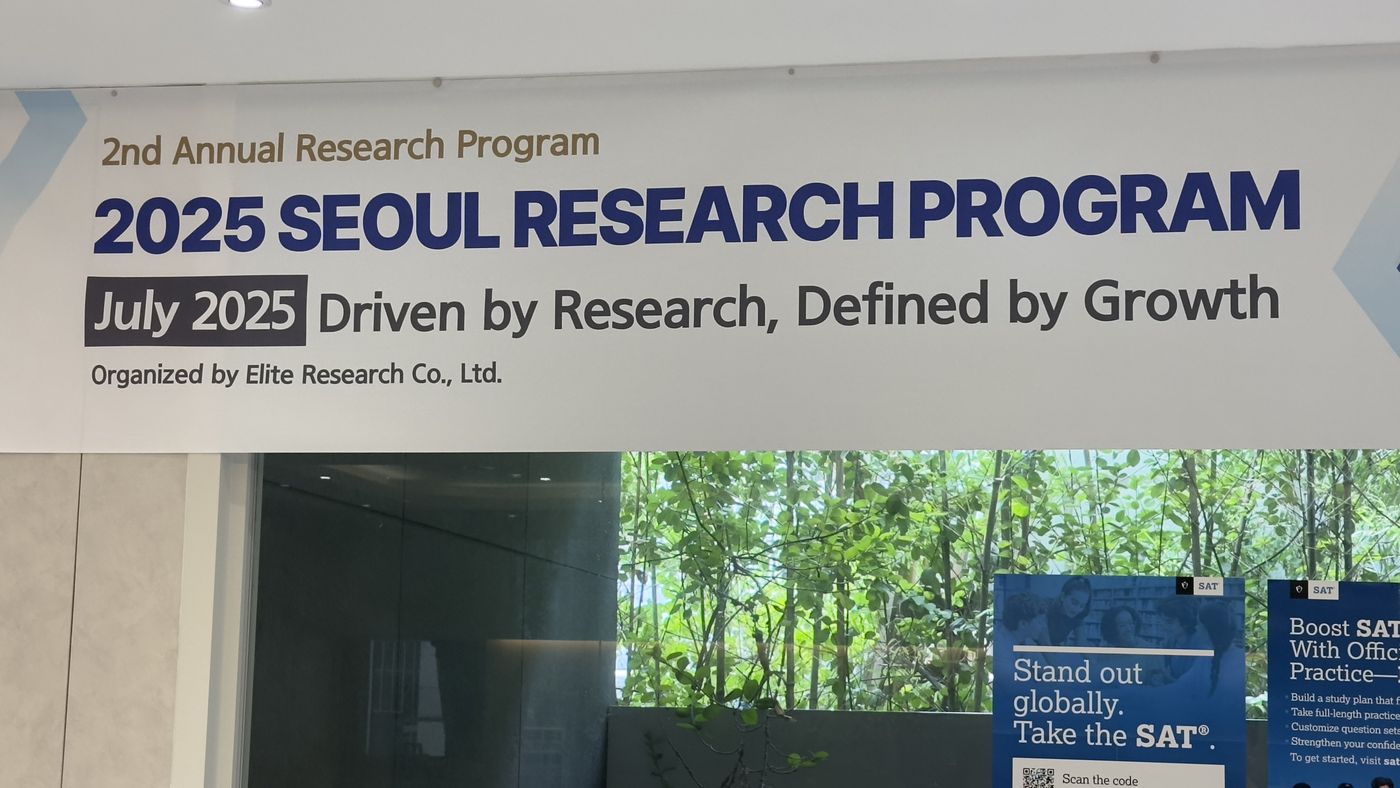 A banner reading "2025 Seoul Research Program, July 2025: Driven by Research, Defined by Growth" hanging above a lobby