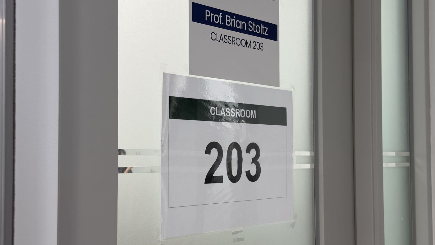A classroom door with signs reading "Prof. Brian Stoltz" and "Classroom 203"